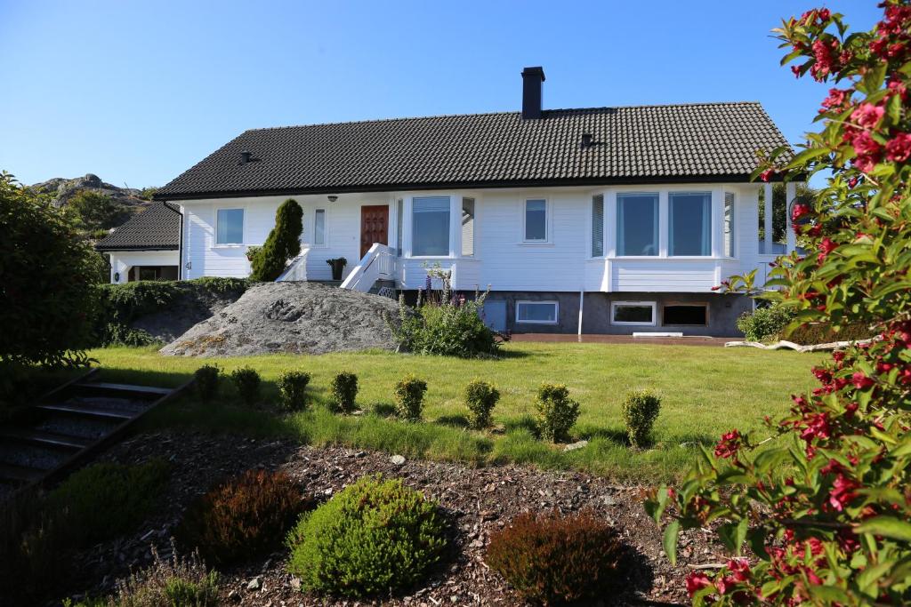 een huis met een grote rots in de tuin bij Sandve in Sandve