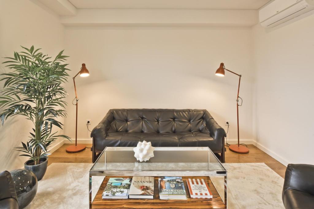 een woonkamer met een leren bank en een tafel bij BmyGuest - Sao Bento Terrace Apartment in Lissabon
