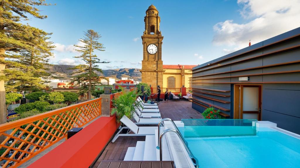 balcone con piscina e torre dell'orologio. di Hotel Emblemático Agáldar a Gáldar