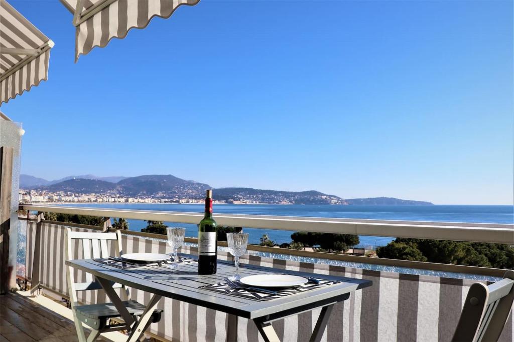 - une table avec une bouteille de vin sur un balcon donnant sur l'océan dans l'établissement 2P NEUF vue Promenade des Anglais / Tram 10min centre, à Nice