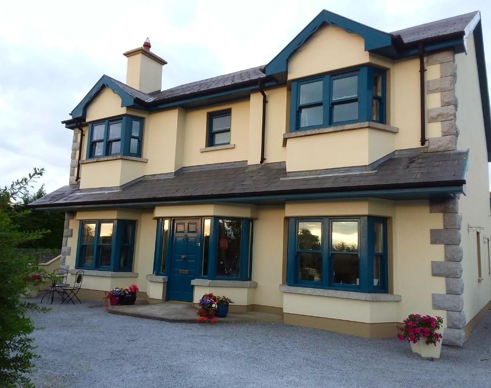 a large yellow house with blue windows at Carriglea in Listowel