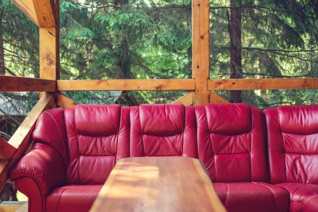 um sofá vermelho com uma mesa de madeira numa cabina em Ski Lake Cottage Krpáčovo em Krpacovo