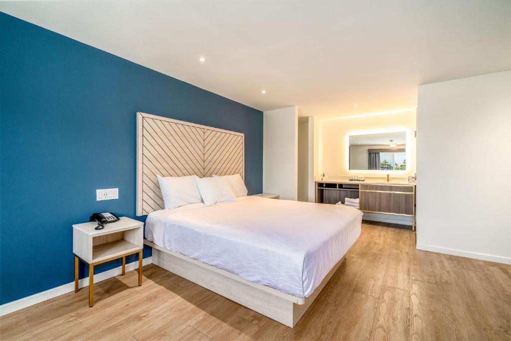 1 dormitorio con 1 cama grande y pared azul en Trend Hotel at LAX Airport, en Inglewood