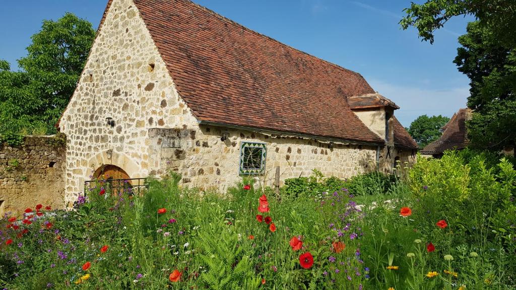 Cénac-et-Saint-JulienにあるGîte Jardins du Périgordの古石造りの花畑教会