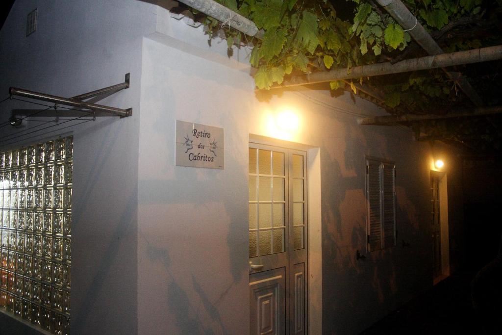 una pared blanca con una puerta y una señal en ella en Retiro dos Cabritos en São Mateus