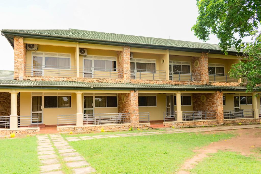 a large yellow building with a lawn in front of it at Soroti Hotel 2001 in Soroti