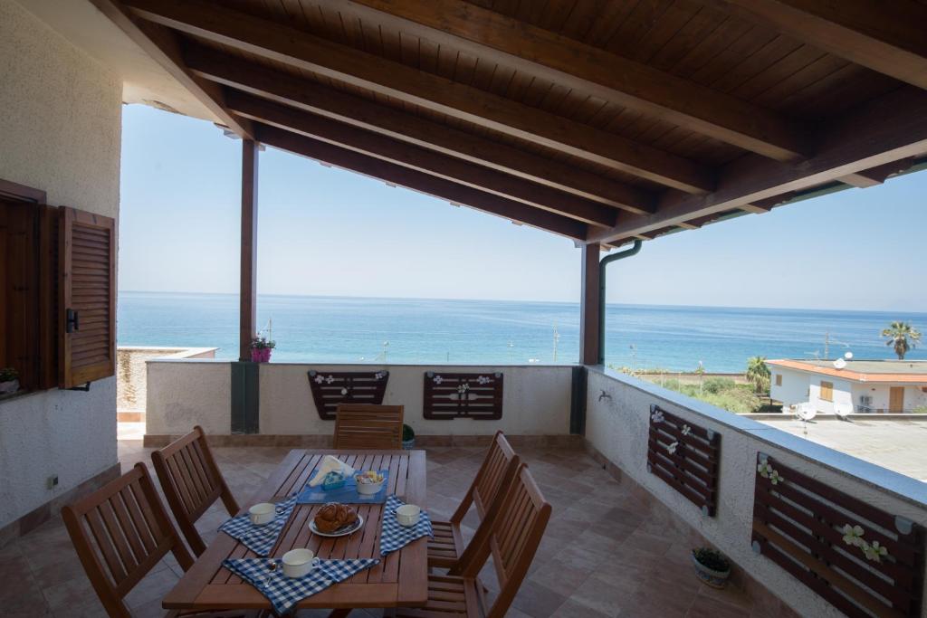 d'un balcon avec une table et des chaises donnant sur l'océan. dans l'établissement BLUE HOUSE by PerryHolidays-Reservations, à Gioiosa Marea