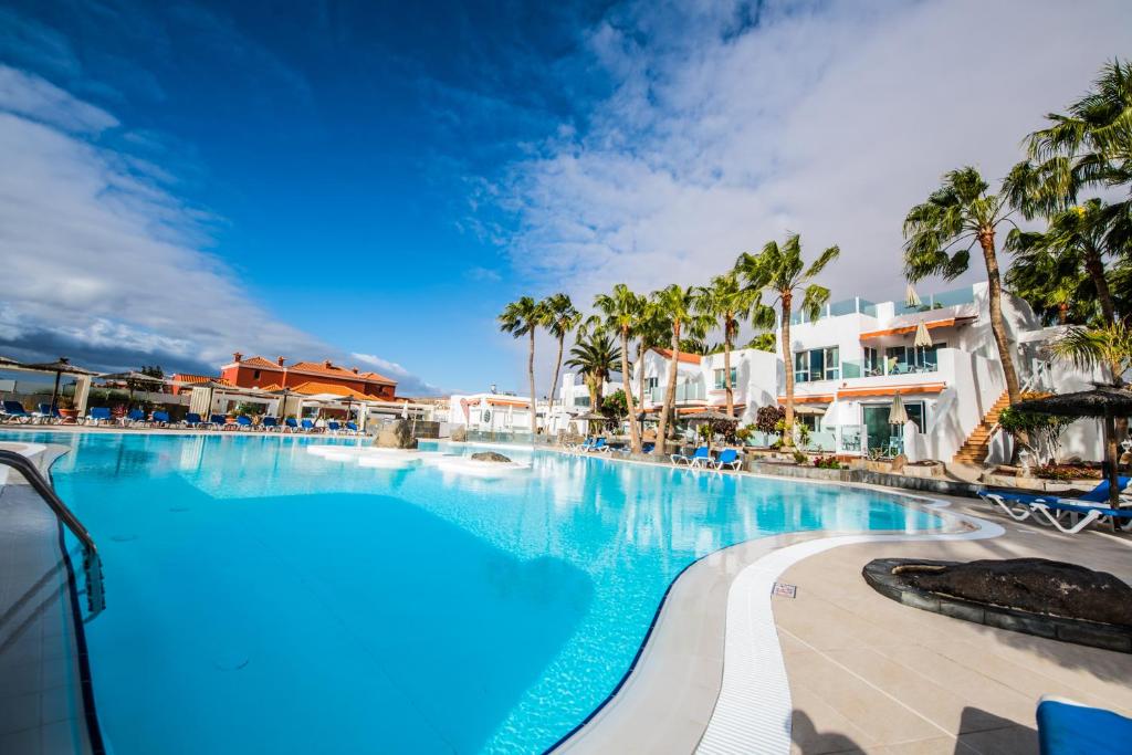 una piscina en un complejo con palmeras en Bahia Calma Beach, en Costa Calma