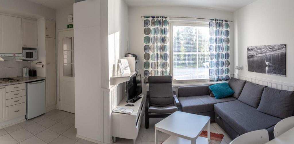 pequeña sala de estar con sofá y cocina en Aparthotel YlläStar, en Äkäslompolo