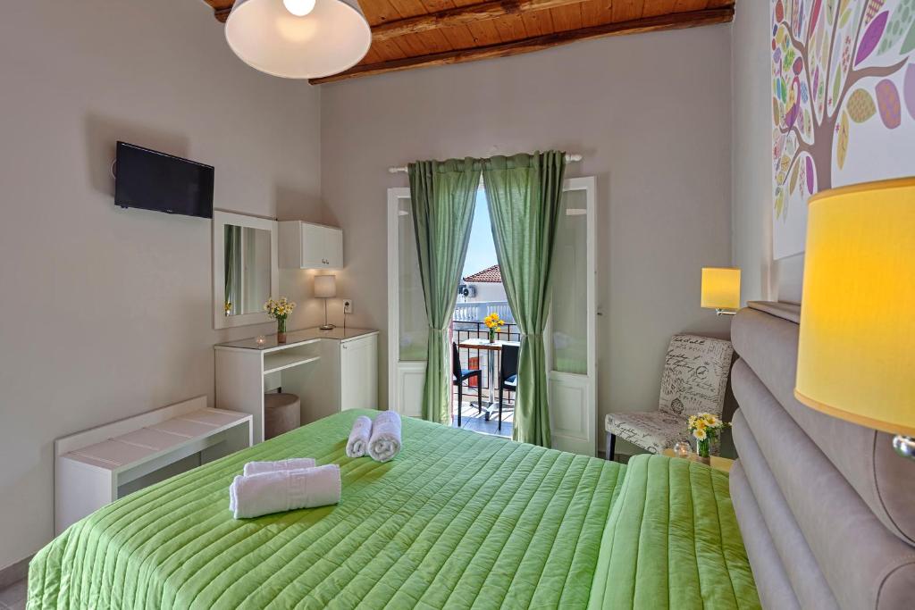 a bedroom with a green bed and a balcony at Paradise in Ermoupoli
