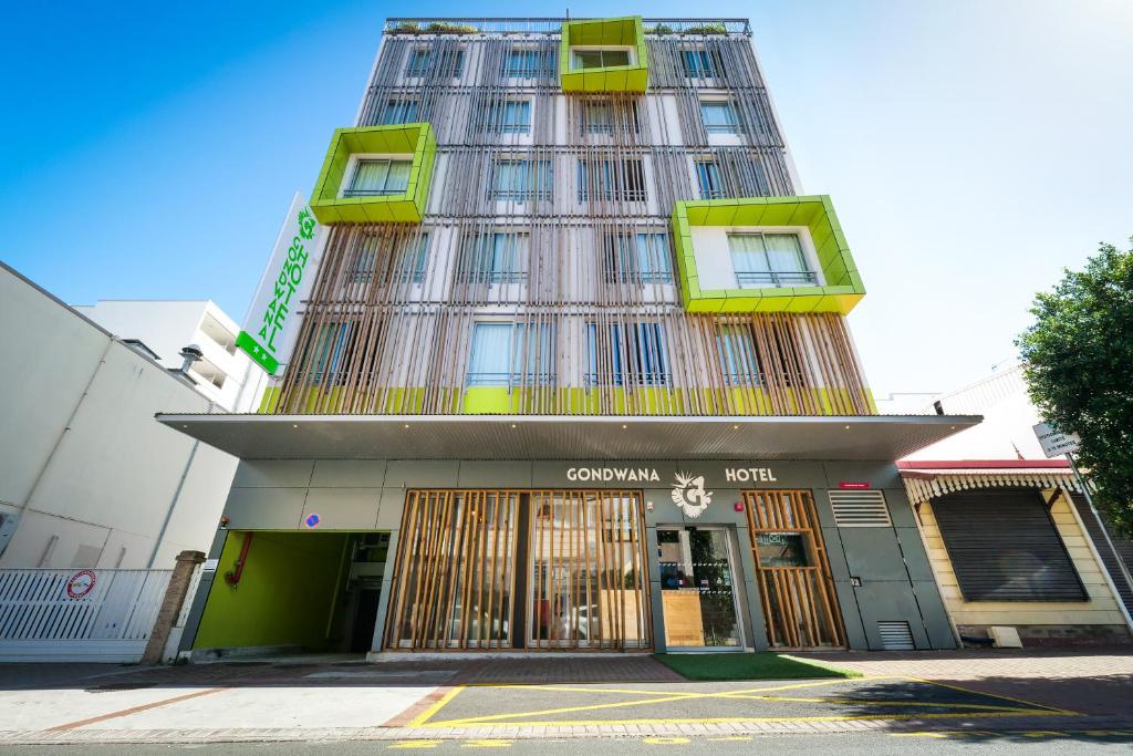 a tall building with green and yellow windows at Gondwana City Green in Noumea