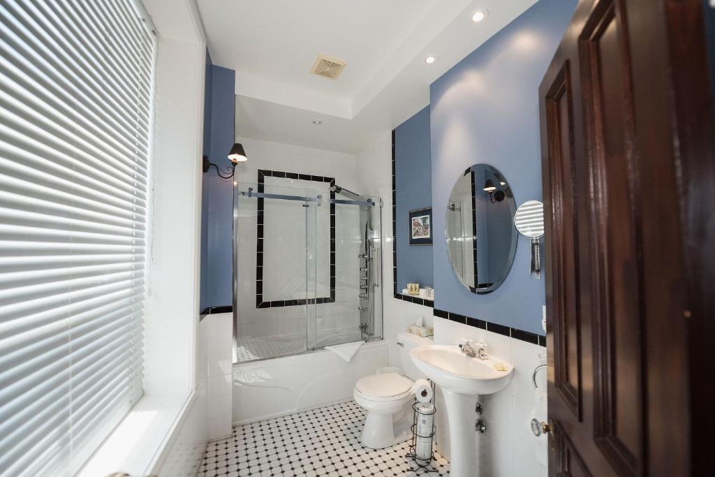 a bathroom with a sink and a toilet and a shower at Manoir Sherbrooke in Montréal