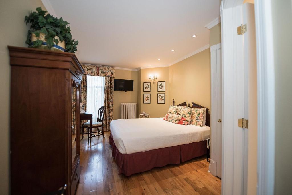 a hotel room with a bed and a desk at Manoir Sherbrooke in Montréal