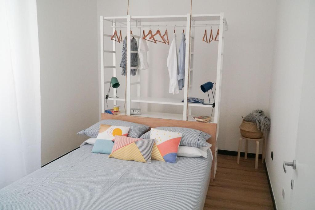 Dormitorio pequeño con cama con almohadas coloridas en Casa Marinin, en Sestri Levante