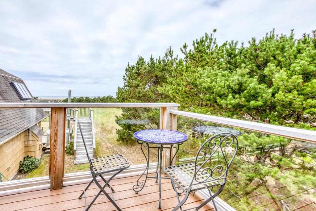 eine Terrasse mit einem Tisch und Stühlen auf einer Terrasse in der Unterkunft Ocean Delight in Warrenton