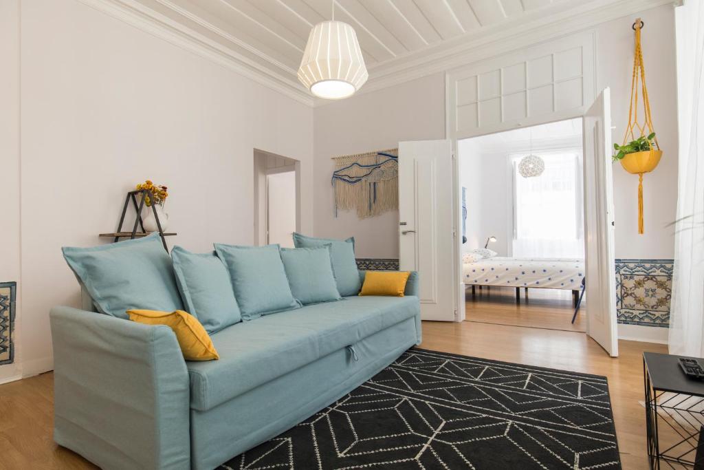 a living room with a blue couch in a room at Blue Tiles in City Center in Lisbon