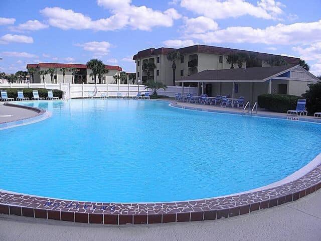 a large blue swimming pool in front of a building at St. Augustine Ocean & Racquet Resort in St. Augustine