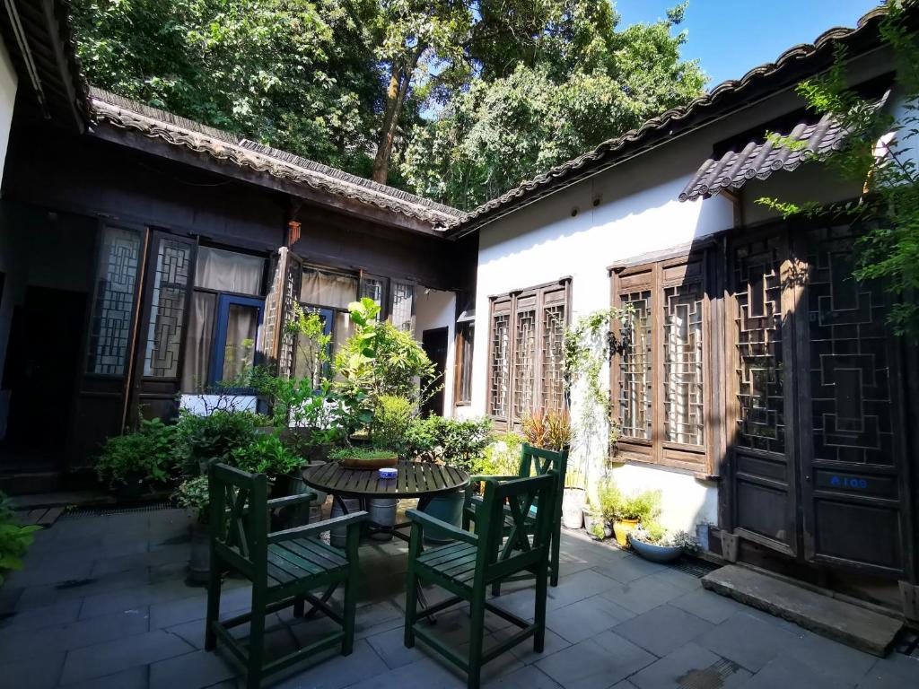 a patio with a table and chairs in front of a building at Hofang Guest House in Hangzhou