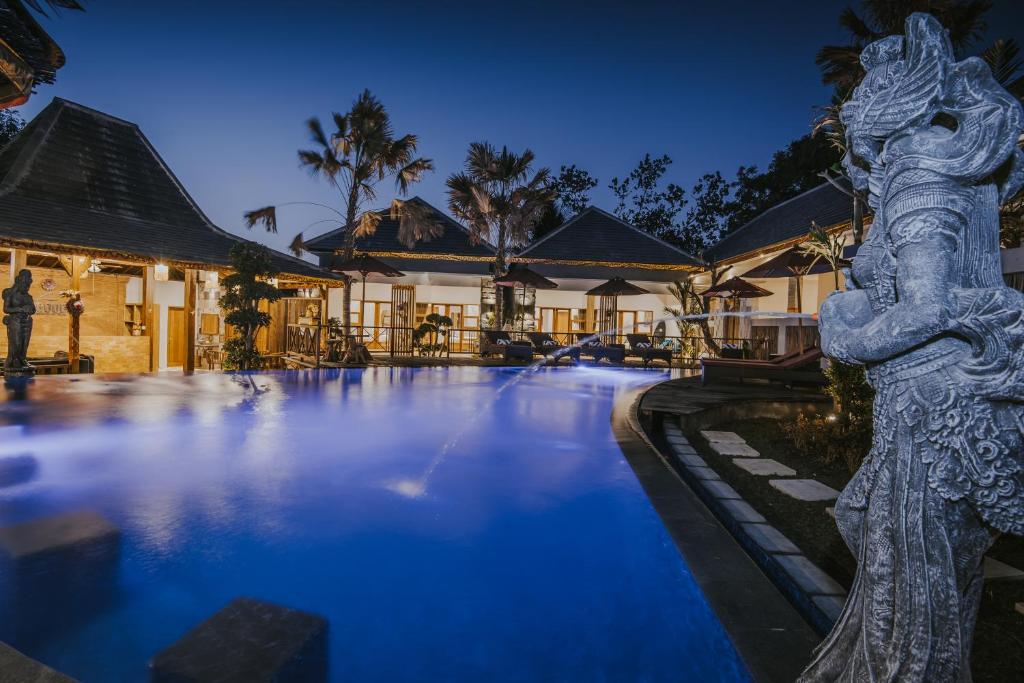 a resort pool with a statue in the middle at LGood Lembongan Island Villas in Nusa Lembongan