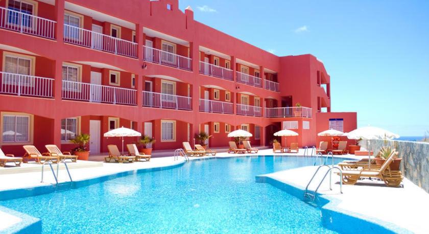 a hotel with a swimming pool in front of a building at Apartamento Paraíso in Costa Calma