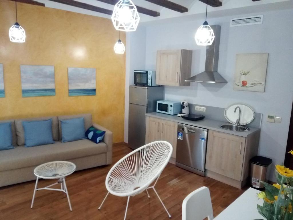 a living room with a couch and a kitchen at Espai One Valencia in Valencia