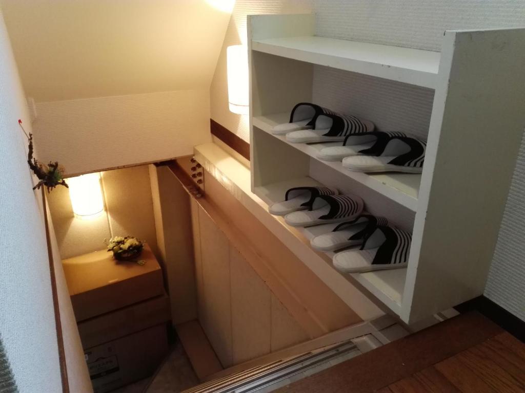 a closet with white towels in a room at FukuokaKoryou GuestHouse in Fukuoka