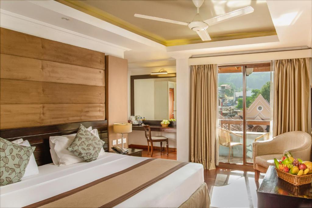 
a bedroom with a large bed and a large window at Kandy City Hotel by Earl's in Kandy
