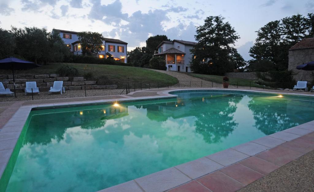 a swimming pool with a house in the background at Hameau Montplaisir in Béziers