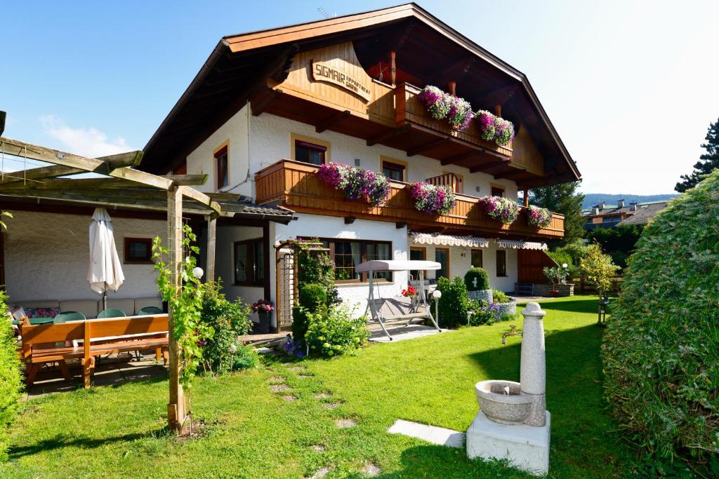 a house with a balcony with flowers on it at Appartements Sigmair in Valdaora