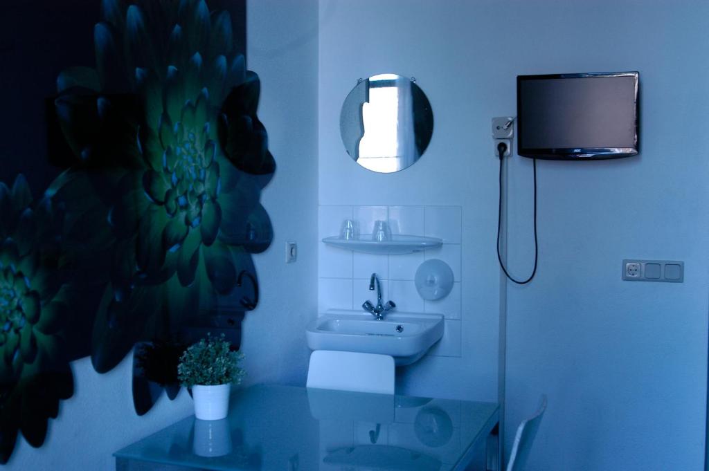 a bathroom with a sink and a toilet and a tv at Rembrandt Square Hotel in Amsterdam