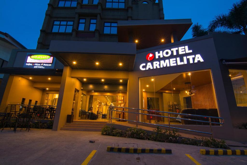 土格加勞的住宿－卡梅利塔酒店，夜间带有酒店标志的酒店卡米利亚建筑