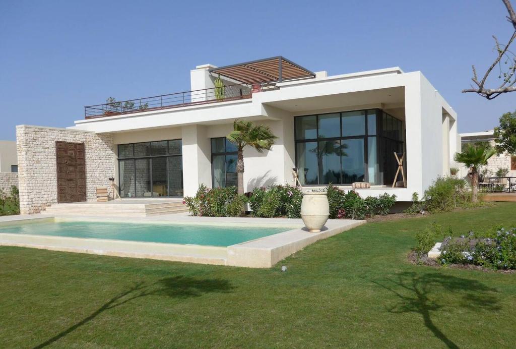 une maison avec une piscine en face de celle-ci dans l'établissement La fiancée du vent, à Essaouira