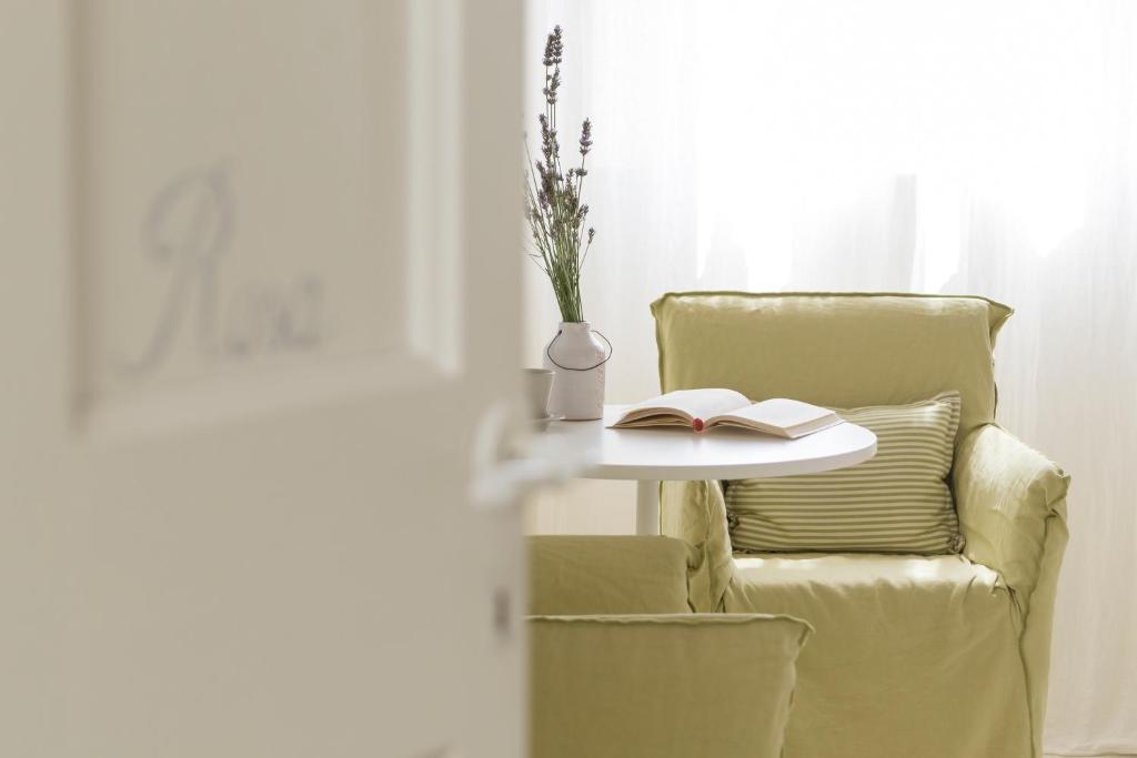 a table and a chair with a book and a vase at B&B Di Charme Le Contrade in Santarcangelo di Romagna