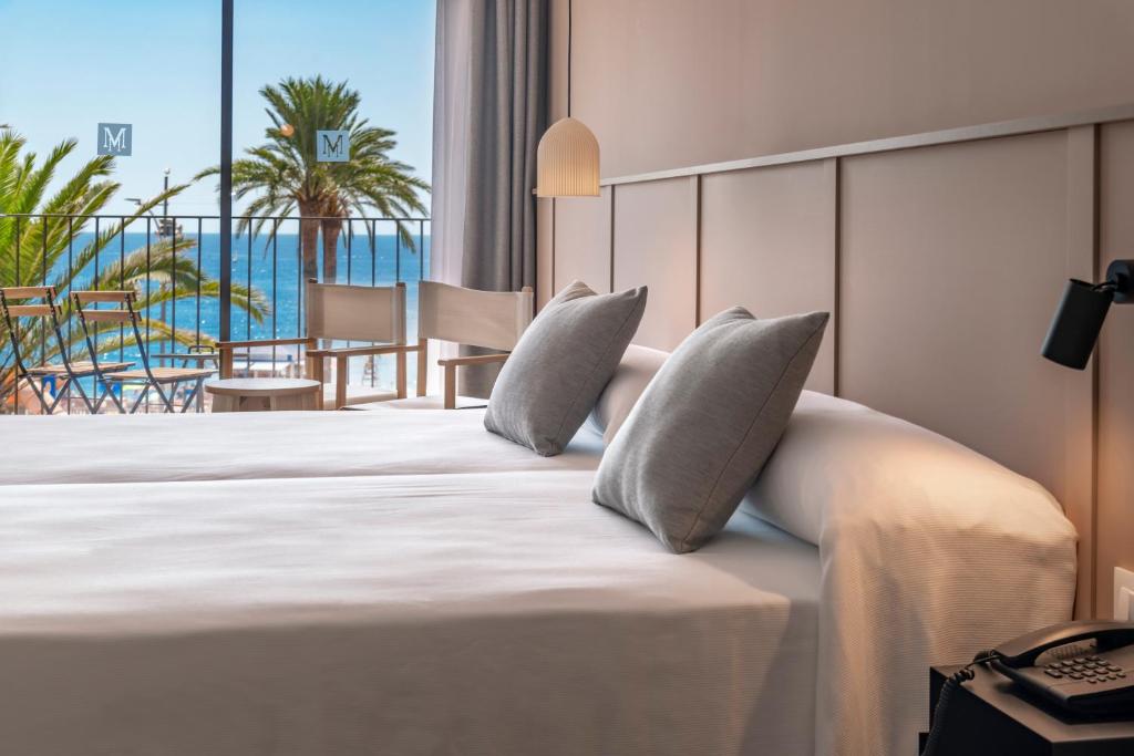 Cette chambre d'hôtel comprend un lit et offre une vue sur l'océan. dans l'établissement GHT Miratge - Only Adults 18 and up, à Lloret de Mar