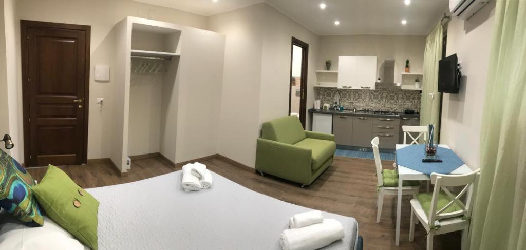 a living room with a bed and a kitchen at TaoZen Apartments in Taormina