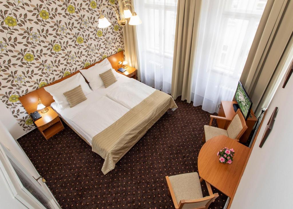 una camera d'albergo con letto e sedia di Novoměstský hotel a Praga