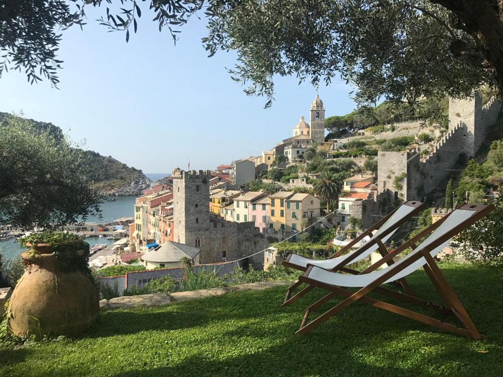 una sedia seduta su un prato di fronte a un castello di Relais Santa Caterina a Portovenere