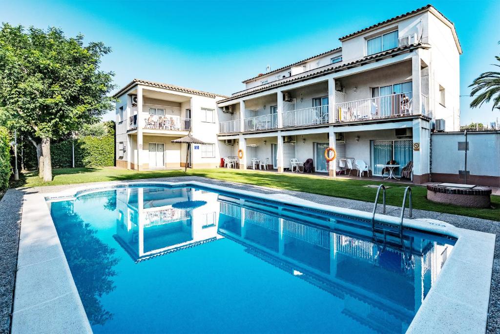 a swimming pool in front of a building at Apartamentos Sunway Tara in Sitges