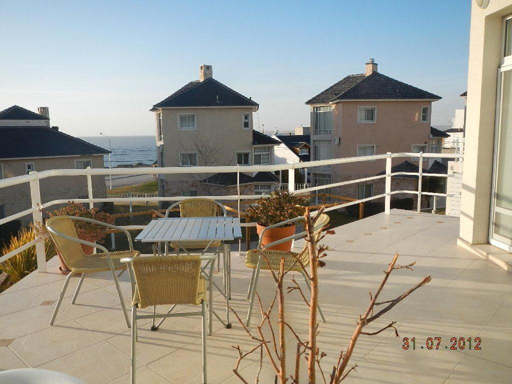 Un patio con sillas y una mesa en el balcón. en Duplex Barrancas en Puerto Madryn