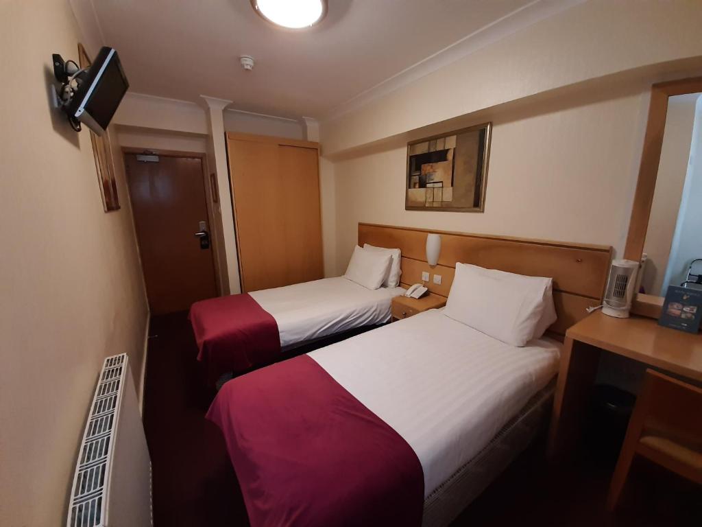 Postel nebo postele na pokoji v ubytování Americana Hotel