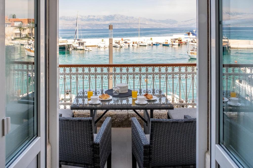 a table on a balcony with a view of the water at Kuća Redini in Sutivan