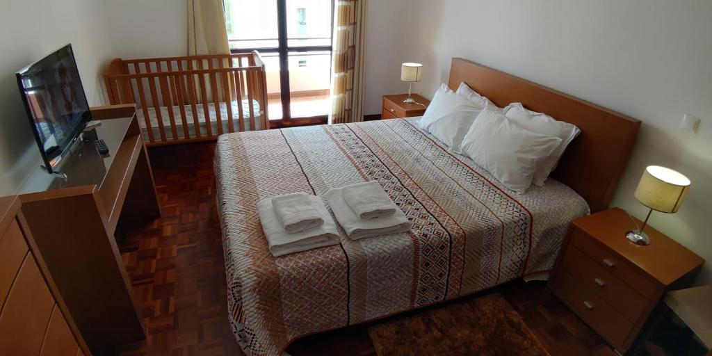 フンシャルにあるJardins Piornais Funchal Apartmentのベッドルーム1室(ベッド1台、タオル2枚付)