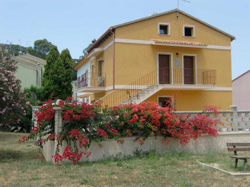 a house with flowers in front of it at La Casa Gialla in Carloforte