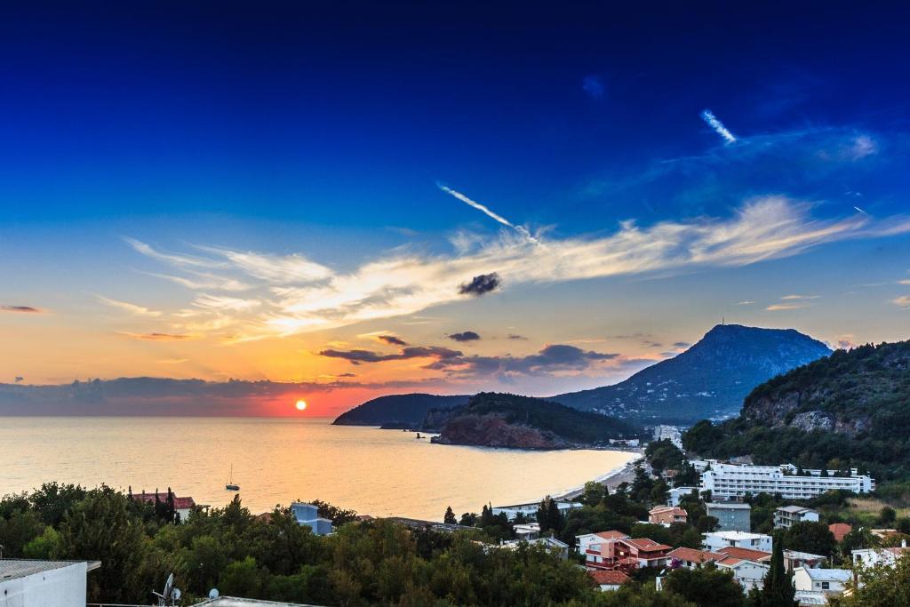 a view of a city and the ocean at sunset at Apartments Sergej in Sutomore