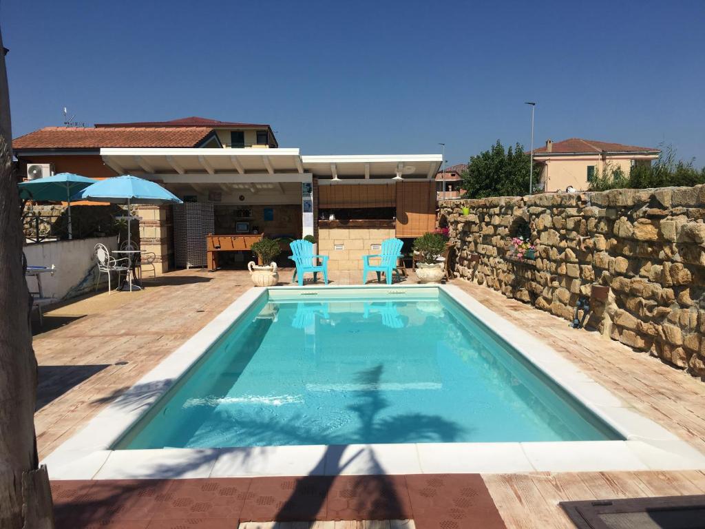 - une piscine en face d'un mur en pierre dans l'établissement B&B Villa Irma guest house, à Crotone
