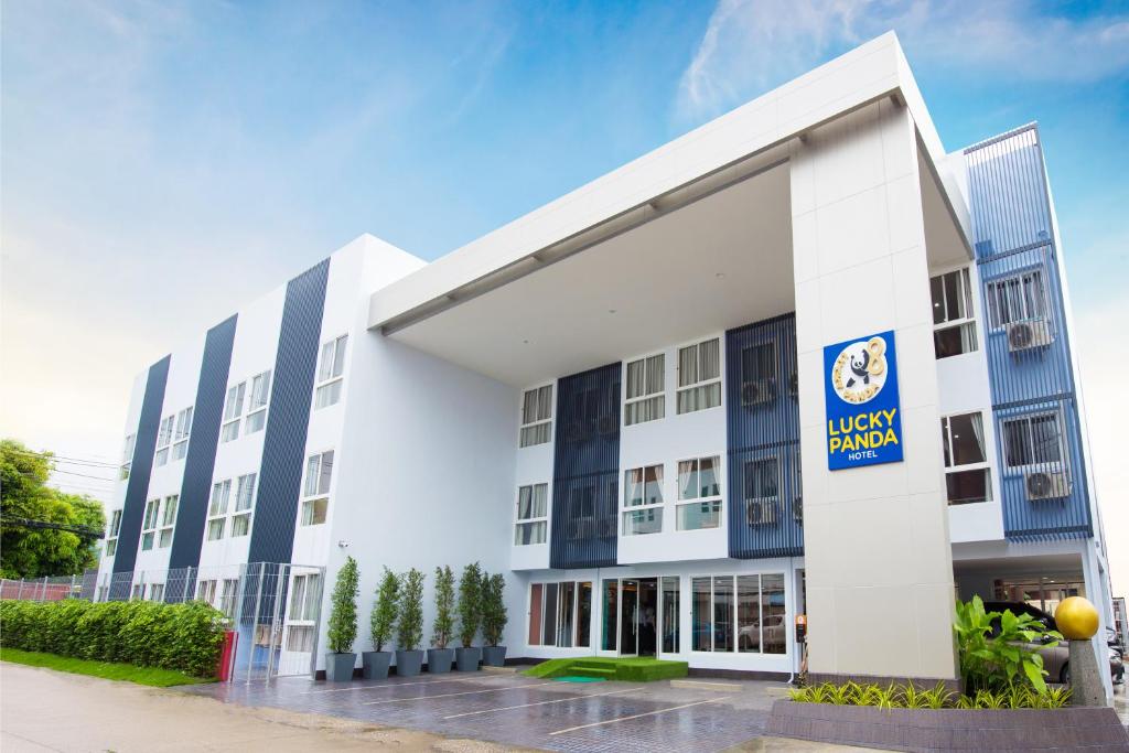 a large white building with a sign on it at Lucky panda Hotel in Chiang Mai