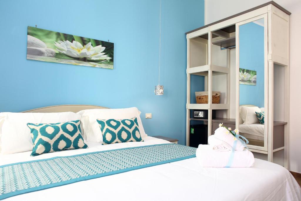 een slaapkamer met blauwe muren en een bed met kussens bij b&b Za Maria in San Vito lo Capo