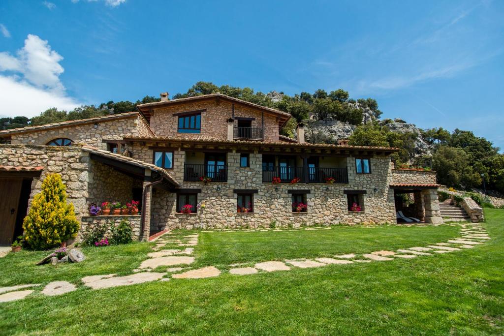 una gran casa de piedra con un patio de césped en Font D'en Torres Solo Adultos, en Morella