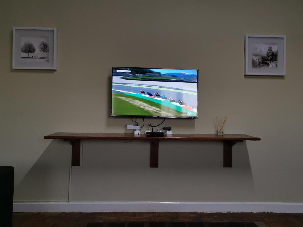una TV a schermo piatto seduta su un muro di TD Guest House 1 a Chimoio