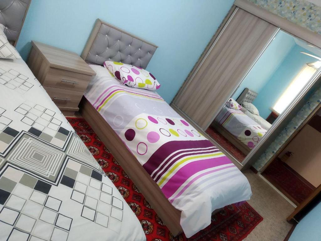 1 dormitorio con cama y espejo en Samia House Twin room, en Tashkent